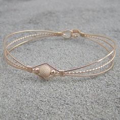 A dainty design of three 14kt gold filled wires with a single 6mm gold filled laser-cut stardust center bead. Delicate and feminine. The built-in hook and eye-type clasp is easy to get on and off. What a sweet, affordable gift for that special girl in your life (even if that special girl is YOU!) Wire Bangles, Bead Bangles, Special Girl, Diy Wire Jewelry, Hand Jewelry, Affordable Gifts, Wire Bracelet, Gold Wire, 14kt Gold