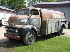 an old rusty truck parked in front of a building