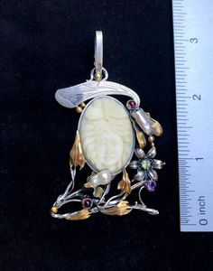 ARTISAN GEMSTONE PENDANTHand-made Sterling Silver. 24k Gold.Stones used: Cameo, Pearls, Peridot, Garnet, Amethyst.Height – 74mm, Width – 40mm.Unique Handcrafted One-of a-kind Design PendantEach Piece of Jewelry in my Collection is Absolutely One of a Kind!When you start wearing a piece of my jewelry you will fall in love with it more and more each day and feel that good Energy and Love that I pass into it while creating this piece of Art.A piece of Art created for you to be inspired and love it Ornate White Carved Jewelry, Exquisite Handmade Ceremonial Jewelry, Elegant One Of A Kind Jewelry For Ceremonial Use, Artisan Carved Pendant Jewelry, White Artisan Jewelry For Ceremonial Occasions, Artisan White Jewelry For Ceremonial Occasions, Ceremonial White Artisan Jewelry, Carved Pendant Jewelry For Wedding, Luxury Carved Pendant Jewelry