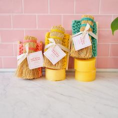 three straw wrapped vases sitting on top of a counter next to a pink brick wall