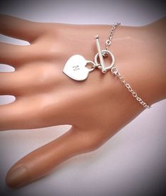 Sterling Silver heart tag Toggle Bracelet. All Metal Components onto 925 Sterling Silver. It could be engraved A-Z any initial , leave on "seller massage box" as you check out. IT is made of .. -Sterling Silver Toggle Clasp, - Sterling Silver Heart Tag pendent , -Sterling Silver cable chain, -Sterling Silver Toggle clasp,  -Come up with ribbon gift box , and -One set of Care instruction package . -it can be stamped custom initial. -All quantities are available for special occasion. MORE HEART NE Metal Bracelet With Toggle Clasp As Gift, Metal Heart Bracelet With Toggle Clasp, Heart Pendant Jewelry With Toggle Clasp As Gift, Silver Heart Jewelry With Toggle Clasp, Silver Heart-shaped Jewelry With Toggle Clasp, Valentine's Day Jewelry Gift With Toggle Clasp, Valentine's Day Gift Jewelry With Toggle Clasp, Metal Heart Bracelet With Toggle Clasp As Gift, Charm Bracelet With Toggle Clasp As A Gift