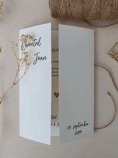 the inside of a wedding card is shown with twine and flowers next to it