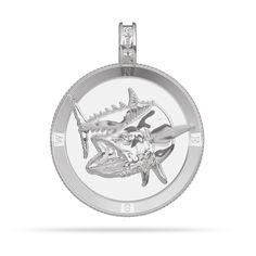 a silver pendant with an image of a fish on it