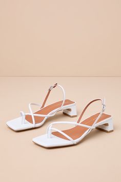 The Intentionally Blank Fifi Ice White Leather Strappy Slingback Low Heel Sandals pair to perfection with warm sunny days! Smooth genuine leather shapes these effortlessly chic sandals that feature a square footbed and a thong-style upper that flows into an asymmetrical strappy vamp. A trendy slingback strap sprouts from the sides and secures at the outstep with a shiny silver buckle. A low, slender block heel completes the coveted look! Available in Euro sizes only. 1. 25" wrapped block heel. C Elegant Slingback Sandals With Block Heel For Vacation, Elegant High Heel Slingback Sandals For Vacation, Chic Summer Slingback Sandals With Heel Loop, Chic High Heel Slingback Sandals For Vacation, Chic Block Heel Slingback Sandals For Beach, Chic Slingback Sandals With Strap For Vacation, Elegant Open Heel Slingback Sandals For Vacation, Elegant Heels With Heel Strap For Vacation, Elegant Vacation Heels With Heel Strap