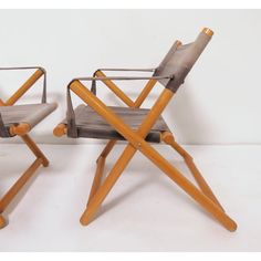 two chairs made out of wood and metal, one with a folding armrests