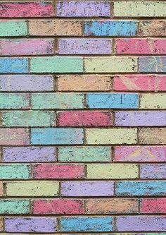 an old brick wall painted in pastel colors