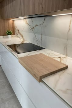 a kitchen counter with a cutting board on it's side next to an oven