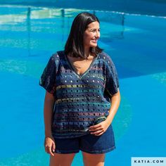 a woman standing in front of a swimming pool with her hands on her hips and looking off to the side