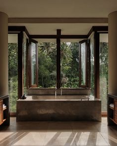 a large bath tub sitting in the middle of a living room next to two windows