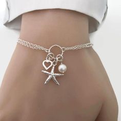 Perfect for a sea lover/sailor/beach wedding. A cute detailed starfish, tiny heart and freshwater pearl charm bracelet in sterling silver. Details: - Material metal: sterling silver - Starfish charm measures 15mm. - Heart charm measures approx. 7mm - Freshwater pearl measure 6-7mm - Adjustable Cheap Silver Charm Bracelet For Beach, Ocean-inspired Starfish Charms Jewelry, Ocean-inspired Bracelet With Starfish Charm, Ocean-inspired Starfish Charm Bracelet, Adjustable Starfish Charm Jewelry, Starfish Charm Strand Jewelry For Gift, Starfish Charm Strand Jewelry Gift, Elegant Starfish Bracelet For Gift, Starfish Charm Bracelet As Gift