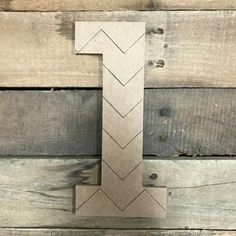 the letter t is made out of wood and has an arrow on it's side