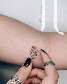 a woman's arm with a heart tattoo on it