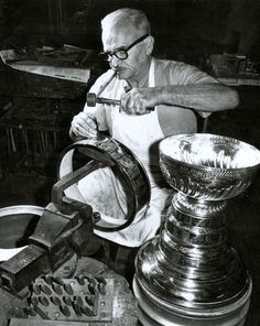 an old man working on some metal items