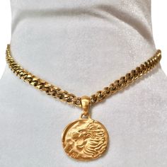 Unleash your inner strength and regality with the Cersei Amulet Necklace, a bold statement piece that exudes power and elegance. This luxurious necklace features a finely detailed lion emblem on a round pendant, symbolizing courage and authority. The pendant hangs from a sturdy, gold-plated curb chain that gleams with a rich luster, making it a standout accessory for any occasion. The necklace is completed with a sleek spike charm that adds an edgy touch, perfect for those who appreciate a mix o Brass Medallion Chain Jewelry, Bronze Tarnish-resistant Medallion Necklace, Spiritual Pendant Coin Necklace With Adjustable Chain, Elegant Medallion Curb Chain Necklaces, Elegant Medallion Necklaces With Curb Chain, Amulet Style Adjustable Chain Necklace With Round Pendant, Brass Box Chain Necklace With Round Pendant, Tarnish Resistant Bronze Pendant Necklace, Bronze Tarnish-resistant Pendant Necklace