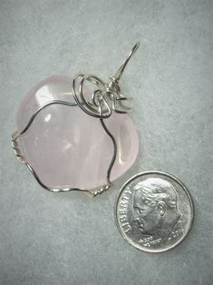 Rose Quartz Heart Pendant Wire Wrapped in .925 Sterling Silver Round Wire This radiant light pink translucent stone heart makes a delightful enhancement when worn with pink, purple or red clothing, elegant with many other colors as well. The heart shape, rather consistent color, and minimal pattern, should appeal to the purist view; artistic appeal may be found in the internal crystal plane and partially cloudy interior. Description: Soft light pink, heart shaped, translucent stone wrapped in 20 Light Pink Heart, Face Unique, Milky Pink, Wire Heart, Minimal Patterns, Red Clothing, Rose Quartz Heart, Stone Wrapping, Stone Heart