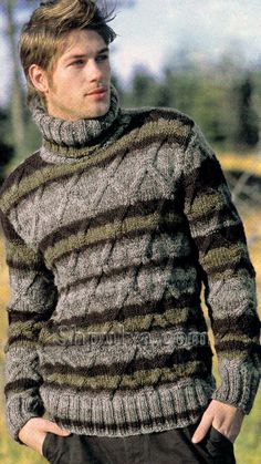 a man standing in the grass wearing a sweater