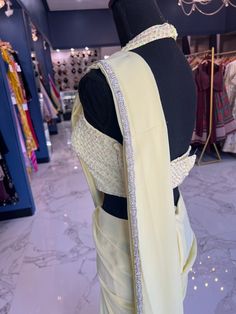 TO ORDER LARGER SIZES, PLEASE WHATSAPP +1 (945) 444-2194 pastel yellow handwork Ready saree accentuated with stone and bead work . Crafted with a halter neckline and a flattering backless design paired with a trendy skirt style bottom and attached pleats. Slight variation in color is possible due to digital photography. Shipping will take 2 weeks,Please WHATSAPP +1 (945) 444-2194 for more info. Ready Saree, Moving To Dallas, Trendy Skirts, Backless Design, Skirt Style, Pastel Yellow, New Launch, Halter Neckline, Indian Design