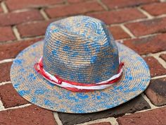 "Unique, one of a kind, hand painted, & designed straw fedora hat.  \"The Merica\" is designed with paint, Sari silk ribbons, & a large red safety pin.  She is patriotic & ready for the beach or poolside!  One size fits most - there is a ribbon in the band to adjust the sizing (circumference of band is 23 in.).  All sales final." Unique Handmade Hat Bands For Beach, Handmade Red Straw Hat With Curved Brim, Adjustable Beach Hat For 4th Of July, Handmade Panama Hat For Kentucky Derby, Adjustable Hand Painted Hat Bands For Beach, Unique Handmade Fedora For The Beach, Unique Handmade Fedora For Beach, Handmade Unique Hat Bands For Summer, Hand Painted Adjustable Fedora For Kentucky Derby