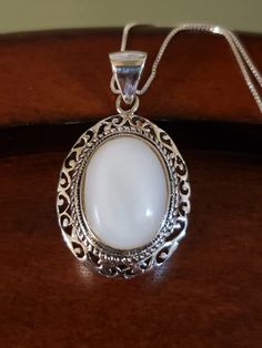 "Beautiful natural MOTHER-OF-PEARL necklace. The 18x14mm oval white Mother of Pearl is surrounded by an intricate, layered bezel setting. It almost looks like a cake from the side🤭 The large bale is hinged, and will certainly accommodate other chains too. Pendant measures 1.5\" long including the bale, and 22mm across. All Sterling Silver, weighs 9.3 grams 18\" Sterling Silver box chain Hallmarked 925 THAILAND (with maker's mark) Brand New Contact me with any questions" White Oval Pearl Pendant Jewelry, Oval Pearl Pendant Jewelry In Pearl White, White Necklace With Intricate Round Design, White Round Necklace With Intricate Design, White Round Necklaces With Intricate Design, Elegant White Oval Cabochon Necklace, Pearl White Oval Necklace With Pearl Pendant, Oval Pearl Pendant Jewelry, White Oval Necklace With Intricate Design