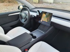 the interior of a car is shown with an electronic device in the center and on the dashboard