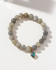 Iridescent hues and blue, green, and gold flashes take center stage in our Labradorite Bracelet. Crafted with genuine Labradorite beads and a coordinating charm, each bead seems to hold a secret universe within, offering an enchanting visual spectacle with every movement.Thanks to its stretch design, this bracelet offers a comfortable and effortless fit, allowing you to slip it on quickly. Whether worn as a standalone statement piece or with other bracelets, it exudes a sense of mystery and soph Labradorite Bead Jewelry As A Gift, Labradorite Beaded Bracelets With Natural Stones As A Gift, Labradorite Healing Bracelets, Spiritual Labradorite Beaded Bracelets As Gift, Healing Labradorite Beaded Bracelets With 8mm Beads, Labradorite Gemstone Beaded Bracelets, Elegant Labradorite Beaded Bracelets, Beaded Labradorite Bracelet, Spiritual Labradorite Beaded Bracelets