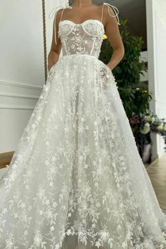 a woman in a white wedding dress standing on the floor with her hands behind her back