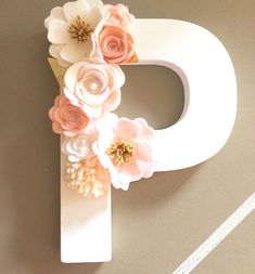 the letter p is decorated with pink and white flowers on it's front end