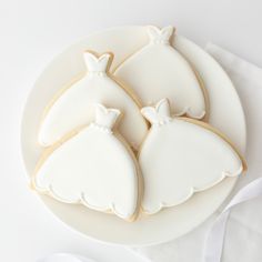 three decorated cookies sitting on top of a white plate