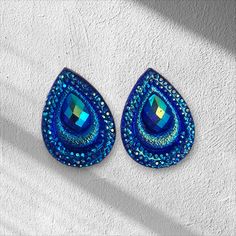 These elegant earrings are handcrafted with rhinestones and flatback beads, measuring 18x25mm in size. They are perfect for occasions such as weddings or everyday wear. Color: Blue Size: 18x25mm Brand: PAIRES Teardrop Crystal Earrings With Rhinestones For Gift, Teardrop Crystal Earrings With Rhinestones, Teardrop Rhinestone Earrings For Gift, Gift Crystal Teardrop Earrings With Rhinestones, Crystal Teardrop Earrings With Rhinestones For Gift, Blue Dangle Earrings With Rhinestones, Elegant Blue Rhinestone Earrings, Blue Sparkling Crystal Earrings, Unique Blue Beaded Nickel-free Earrings