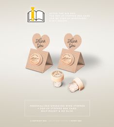 two wine corks with the words thank you on them next to an open book