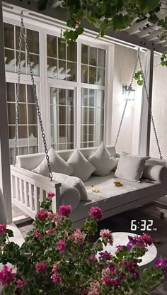 a porch swing bed with flowers in the foreground