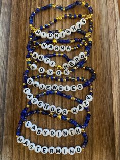 the beaded name bracelets are arranged on a wooden surface with beads and letters that spell out names