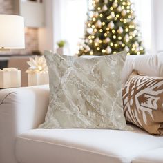 a living room with a white couch and christmas tree in the backgroung