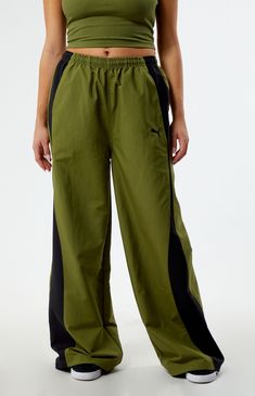 Elevate your athleisure wardrobe with Puma's Green Dare To Relaxed Parachute Pants. Unleash comfort and style with these relaxed-fit pants, boasting a trendy parachute design that seamlessly blends performance and fashion for a bold, sporty look.


	Solid color parachute pants
	13.5" rise
	29" inseam
	Lightweight construction
	High-rise
	Interior drawstring waistband
	Contrast side stripes
	Side hand pockets
	Back flap pocket
	Puma embroidery
	Bungee drawcord ankle cuffs
	Relaxed fit Parachute Design, Athleisure Wardrobe, Ankle Cuffs, Fit Pants, Sporty Look, Side Stripe, Drawstring Waistband, Model Measurements, Workout Pants