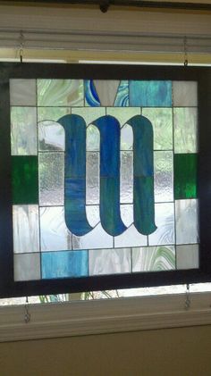 a stained glass window with the letter u on it in front of a door frame