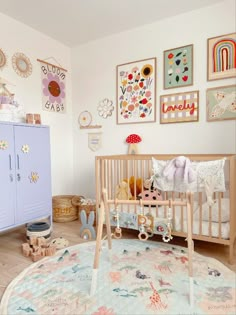 a baby's room with several pictures on the wall and a crib next to it