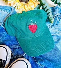 A embroidered strawberry on a green base ball cap. Novelty Green Hats With Curved Brim, Novelty Cotton Adjustable Baseball Cap, Novelty Green Hat With Curved Brim, Fun Spring Brimmed Baseball Cap, Cute Adjustable Baseball Cap With Short Brim, Fun Spring Baseball Cap, Whimsical Cotton Hats For Spring, Trendy Brimmed Cotton Baseball Cap, Playful Adjustable Cotton Baseball Cap