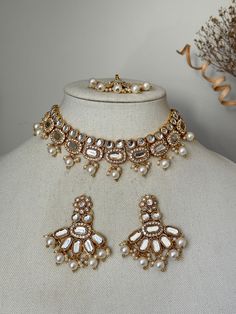 pearl kundan set with earrings x tikka  earring length- 1.5 inches Style tip- ----------- Pair it with any beautiful traditional outfits  and flaunt with Unique style of collection from us. Perfect match for Festival and Traditional wear.  Take Care Tips-  ---------------- Kee away from perfume, Hair spray and. Moisture.  Store in dry place , Ziplock bag or Airtight box.    Clean with dry cloth.  Jewellery is the last thing you should wear and first thing you should remove.  -------------------- Luxury Kundan Temple Jewelry Earrings, Luxury White Necklaces For Diwali, Cheap White Jewelry For Puja, Luxury Kundan Hand Set Tikka, Luxury Kundan Jewelry Sets With Latkans, Luxury Kundan Pearl Earrings In Temple Style, Luxury Kundan Temple Jewelry Pearl Earrings, Indian Bridal Jewelry Sets Brides Totaram Jewelers, Luxury Kundan Temple Jewelry Sets