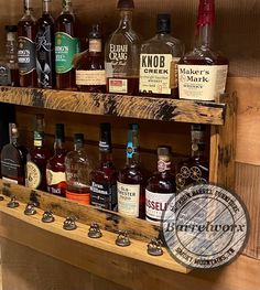 a wooden shelf filled with lots of different types of alcohol bottles on top of it