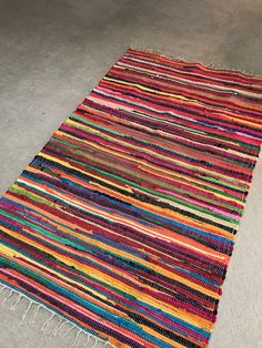 a multicolored rug with fringes on the floor