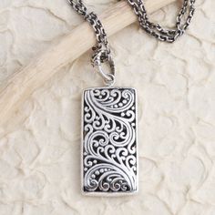 Bali's Yuniati engraves the rectangular pendant on this charming necklace with traditional Balinese designs. Crafted from sterling silver the necklace is equipped with a cable chain and completed with a combination finish. Sterling Silver Engraved Rectangular Pendant Jewelry, Unique Silver Necklace With Rectangular Pendant, Engraved Sterling Silver Rectangular Pendant Jewelry, Symbolic Sterling Silver Necklace With Rectangular Pendant, Antique Silver Rectangular Pendant Jewelry, Sterling Silver Necklace Pendants, Silver Spring, Silver Pendant Necklace, Cable Chain