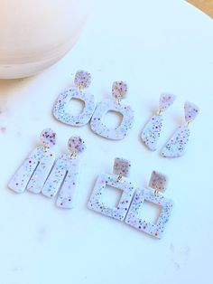 four pairs of earrings sitting on top of a table