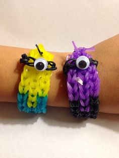 two bracelets with googly eyes are on someone's arm, one is yellow and the other is purple