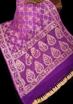 Presenting an authentic saree that comes with iconic work from two states - Banarasi weave from Uttar Pradesh and Bandhej from Gujarat. The saree has actually been transported and worked on, in these 2 states to make it as authentic as possible. Set in a popular shades of Purple and lilac, the saree features intricate Bandhej hand plucked and resist dyed motifs. Zari work sprawls all over the borders and pallu in trendy designs. Caged heels and statement jewellery can make a good pair, telling t 2 States, Caged Heels, Saree Blouses, Statement Jewellery, Zari Work, Georgette Saree, Purple Silk, Trendy Designs, Uttar Pradesh