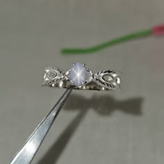 a close up of a pair of scissors with a ring in the shape of a flower