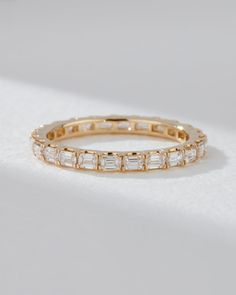 a yellow gold band with baguets on the side and diamonds in the middle