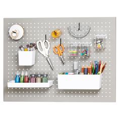 there are many craft supplies on the pegboard with scissors, tape and other items