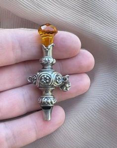 This antique nanny's whistle/rattle is made of sterling silver (.925) and features a Victorian style. The whistle/rattle has Scottish origins and is a unique addition to any antique silver collection.  This unique and rare Nanny's whistle has a Citrine stone at the top.  No chips or cracks.  The neck at the base of the citrine has a hallmark in the silver of an Anchor and two other symbols, which are hard to read.  It is missing one of its bells.  Has a ring that would attach to a nanny's chatel Shifting Closet, Antique Stuff, Best Garden Tools, Fancy Stuff, Ring Bell, Silver Collection, Room Deco, Jewelry Workshop, Victorian Rings