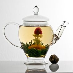 a glass tea pot filled with green tea