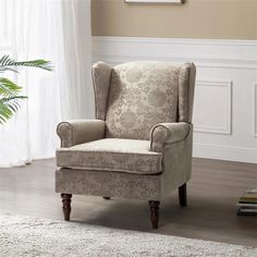 a chair in a living room with a rug on the floor and a potted plant next to it